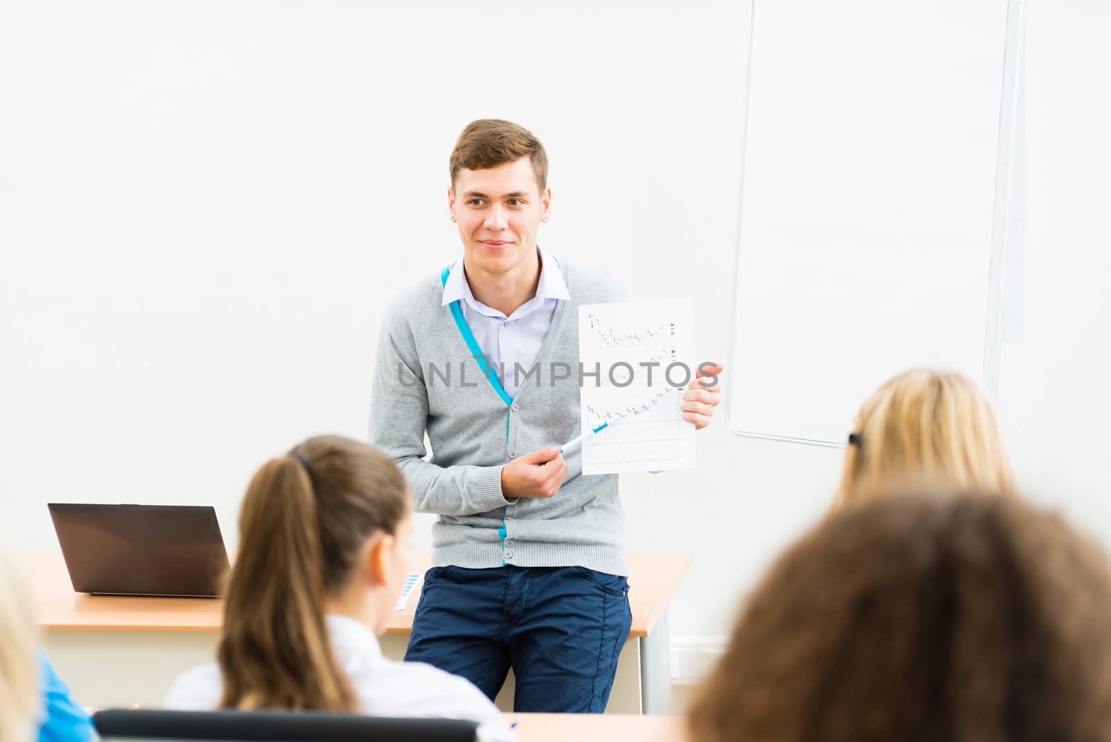 young teacher man talking with students in the classroom