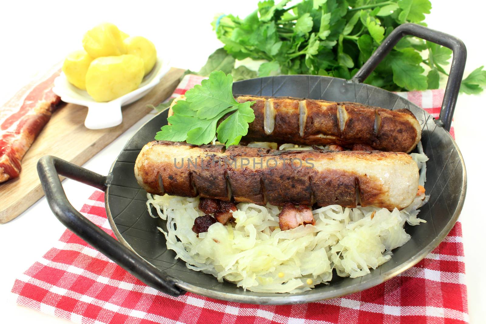 a pan with sourcrout and fried sausage