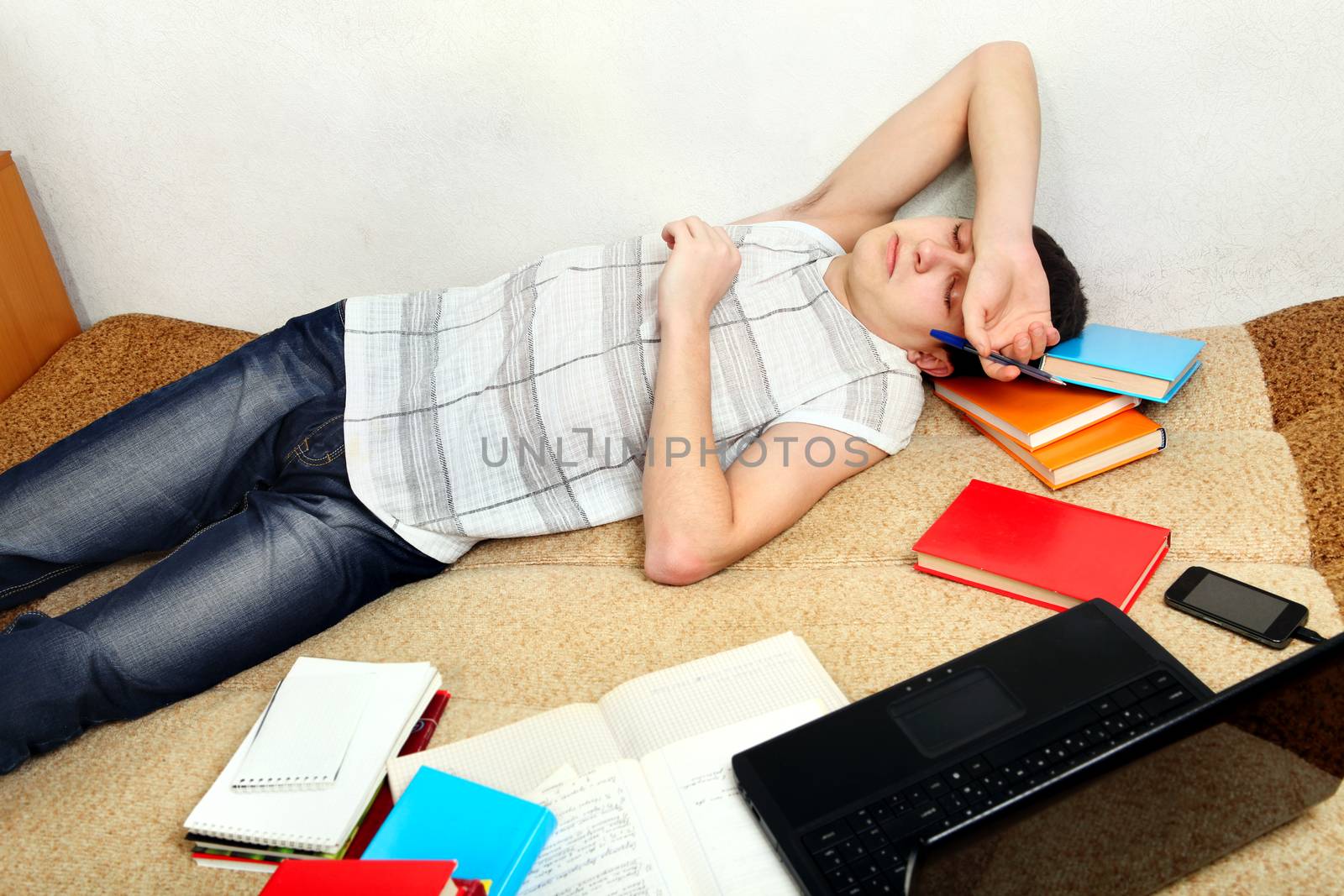 Teenager sleeps after Learning on the Sofa at the Home