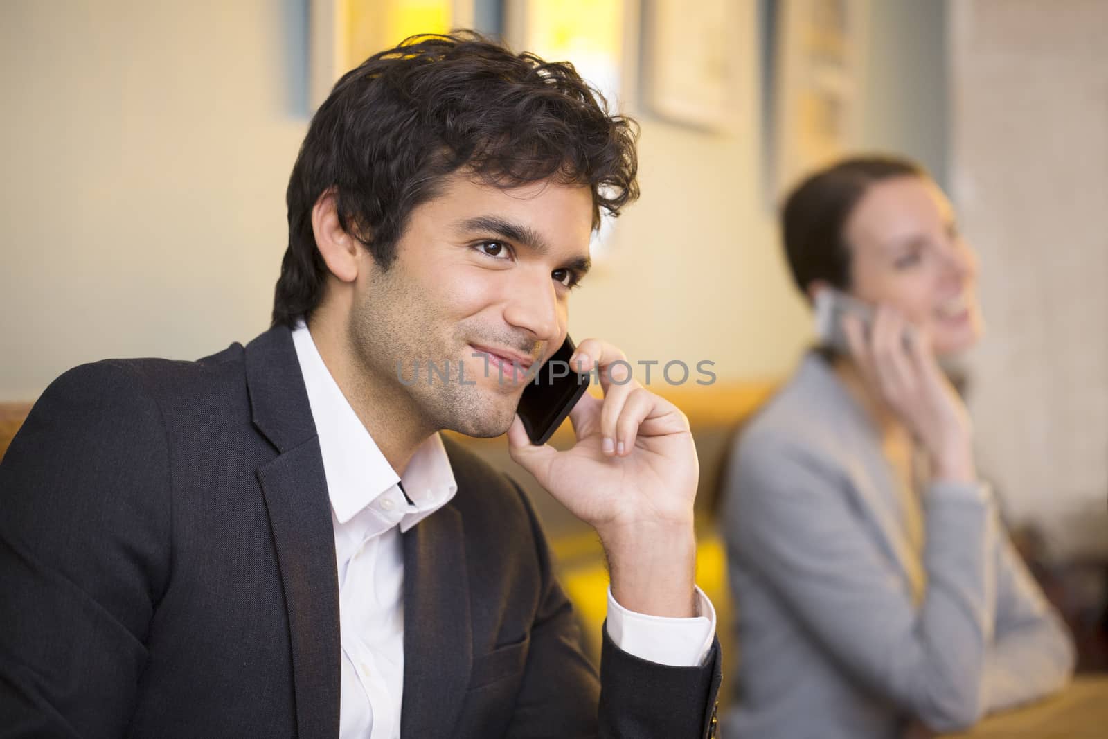 Handsome man on cell phone in coffee bar  by LDProd