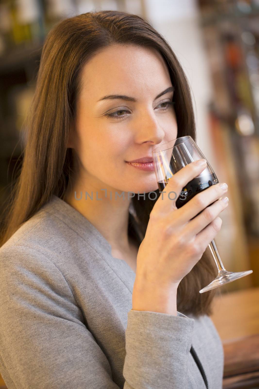 Portrait of pretty young woman feeling red wine in restaurant by LDProd