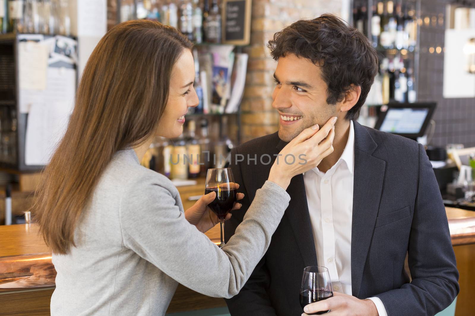 Loving couple takes a drink in  restaurant, a tender moment by LDProd