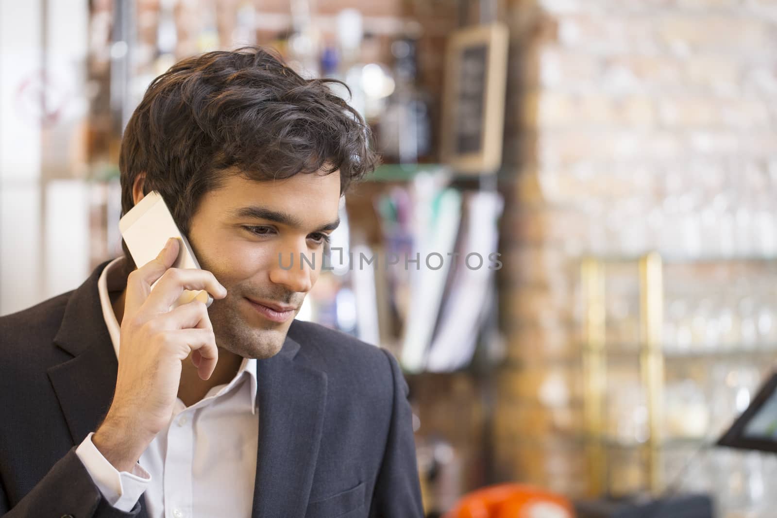 Handsome man calling with a cell phone in coffee bar by LDProd