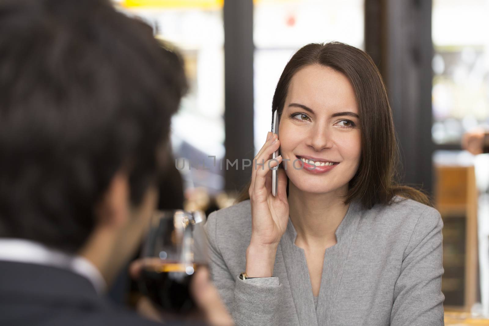 Young couple in restaurant breakfasted, woman is on the phone by LDProd