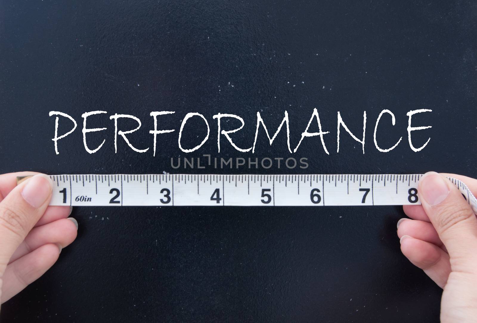 Tape measurement of the word performance on a chalkboard 
