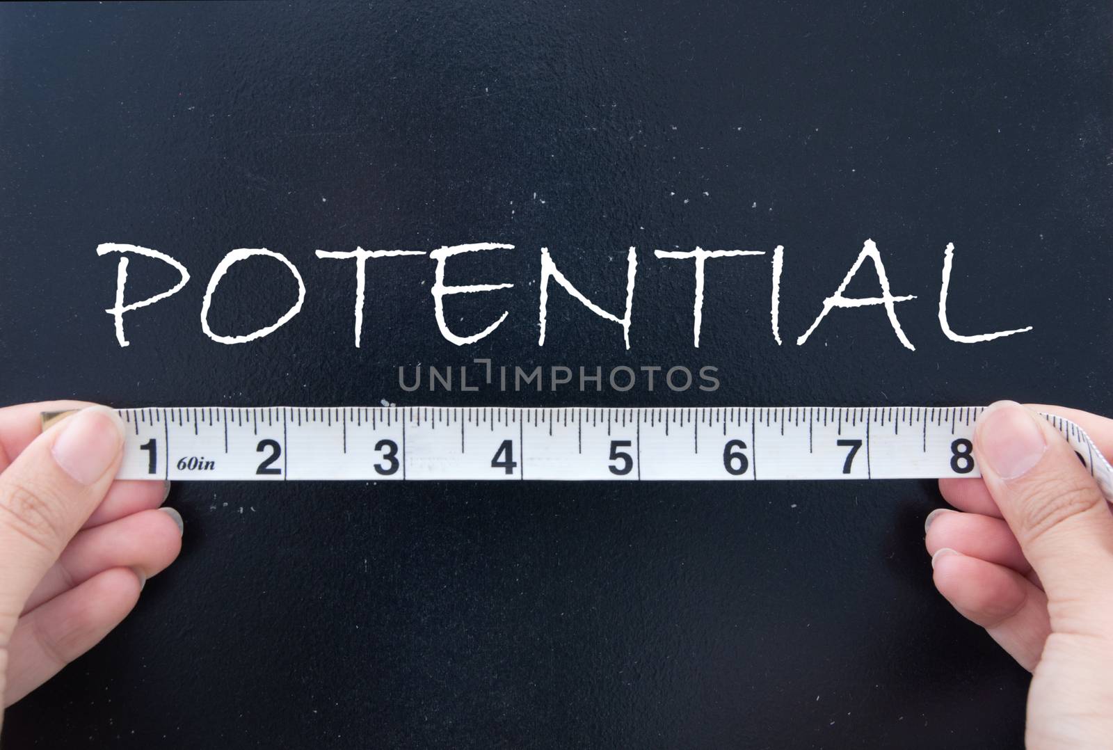 Tape measurement of the word potential on a chalkboard 