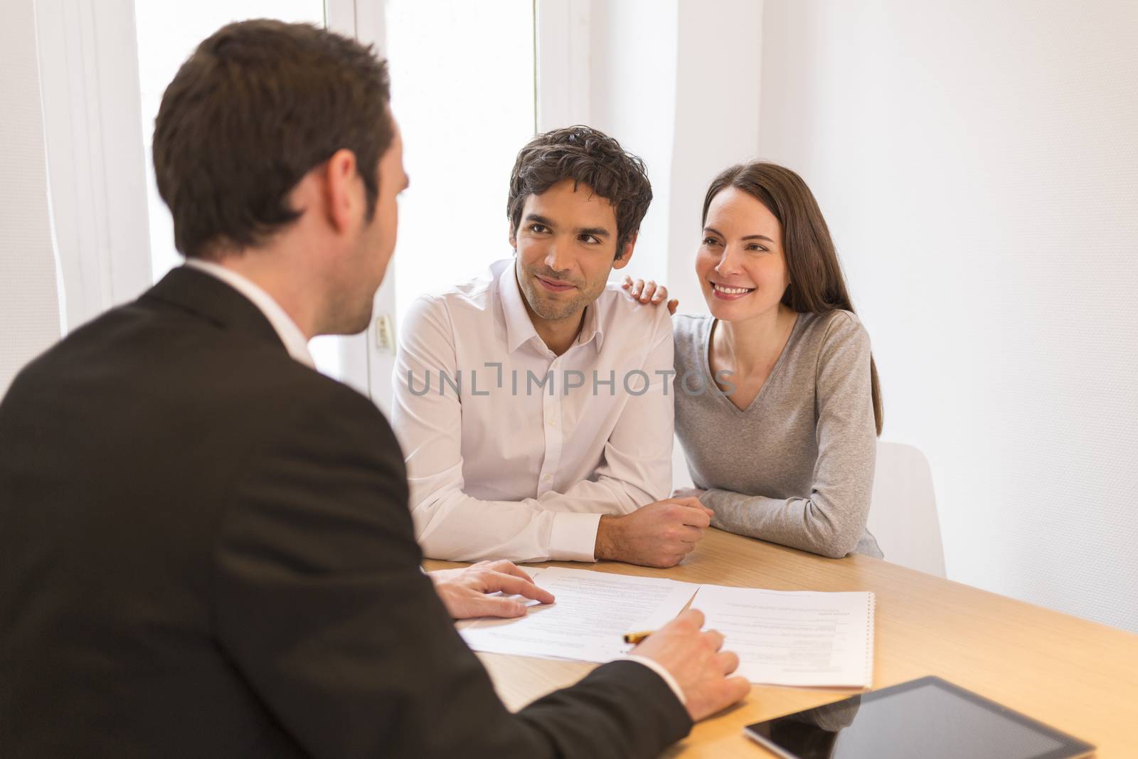 Young Couple meeting real-estate agent to buy property by LDProd