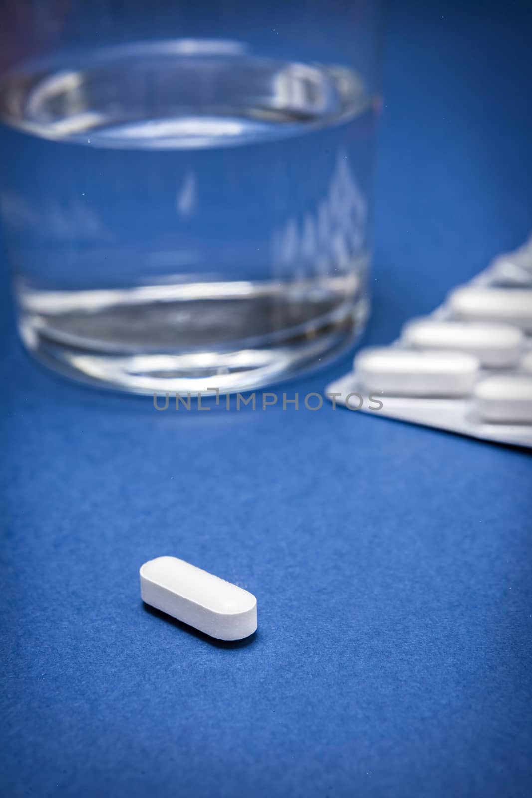 Water glass with pads isolated on a blue background