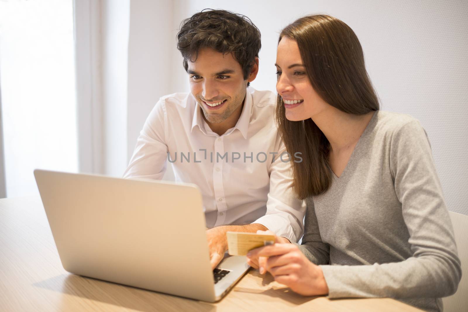 Couple using credit card to shop on line. Laptop. Indoor desk by LDProd