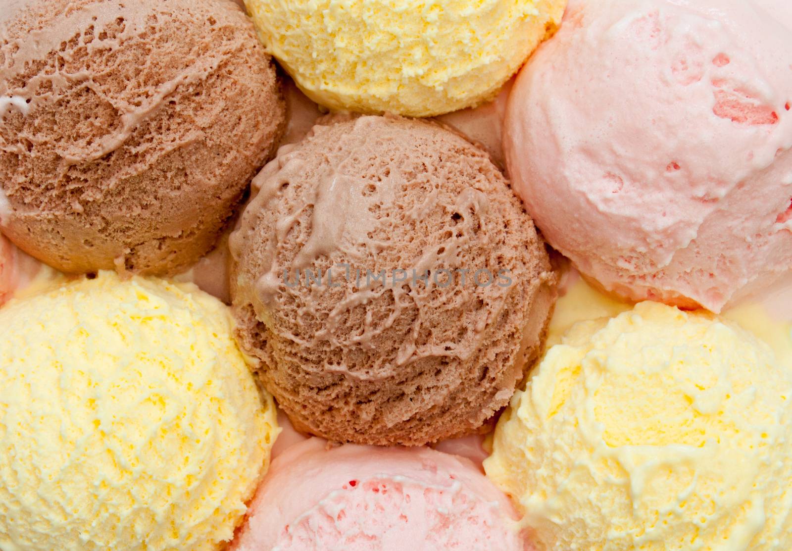 Scoops of different flavored icecream including vanilla, strawberry and chocolate 
