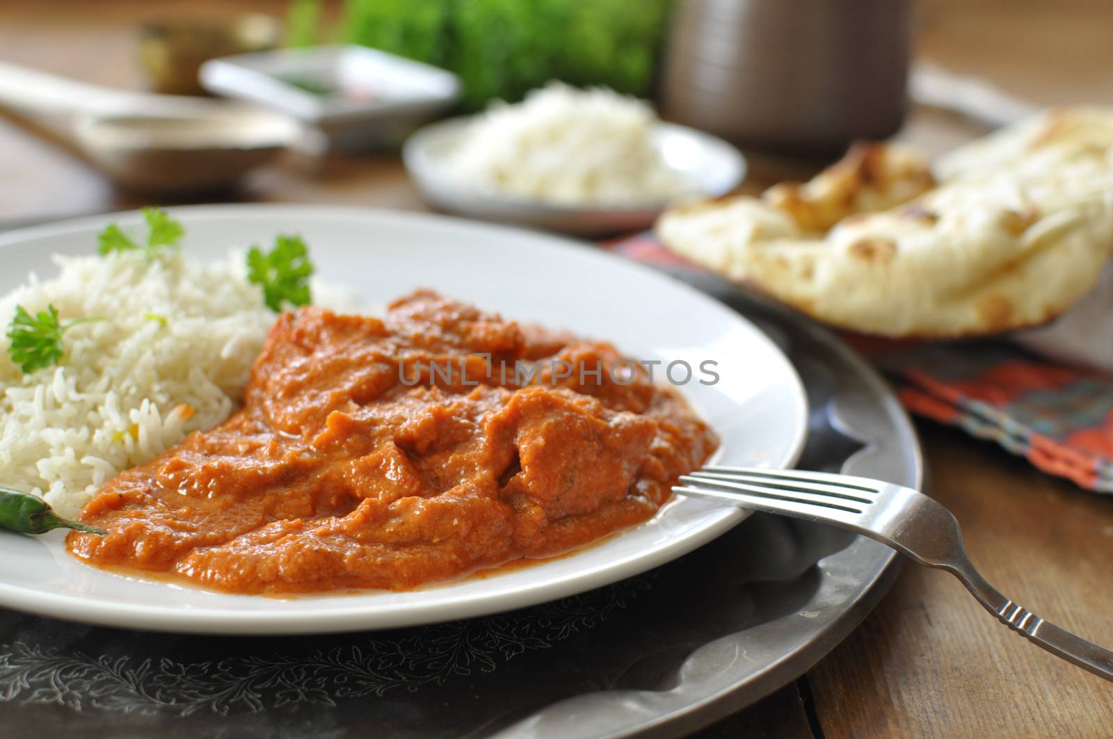 Chicken curry on a plate with rice an chilli pepper 