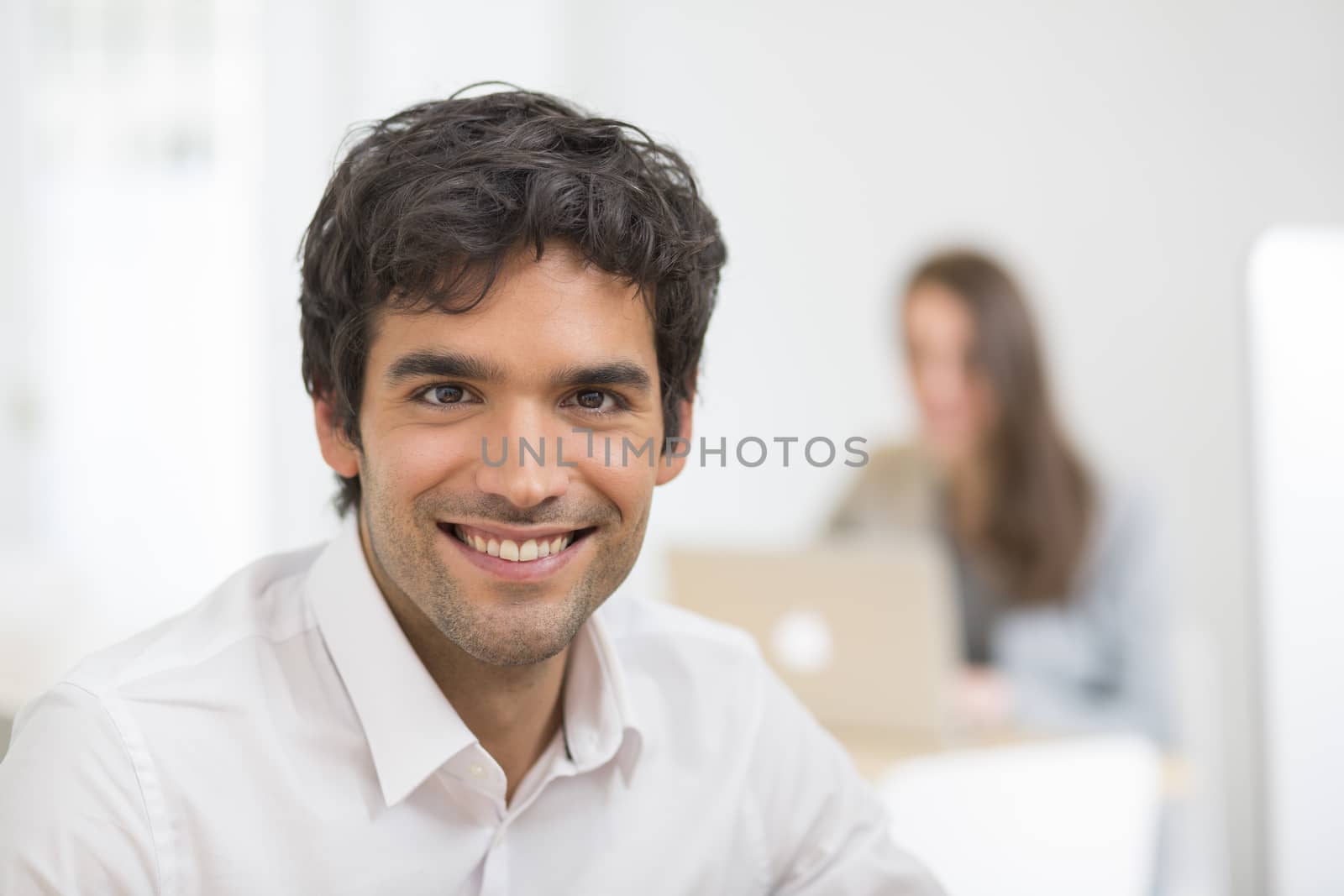 Portrait of businessman working on computer in office, looking c by LDProd