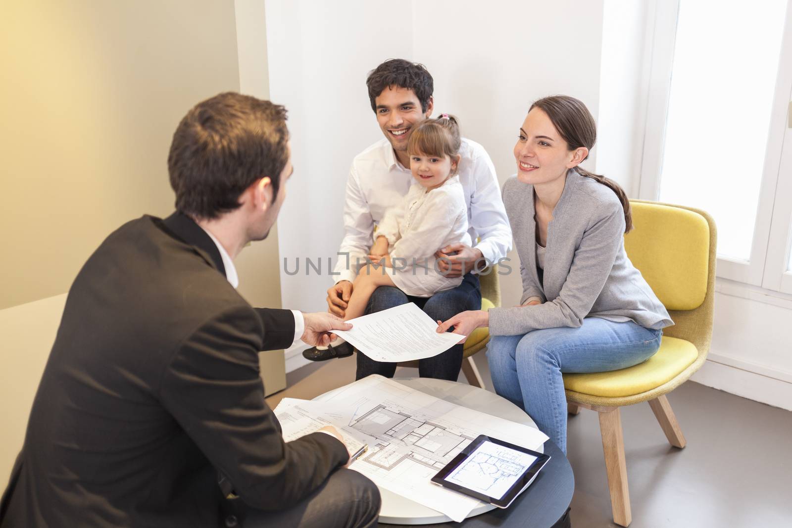 Young Family meeting real-estate agent to buy property by LDProd