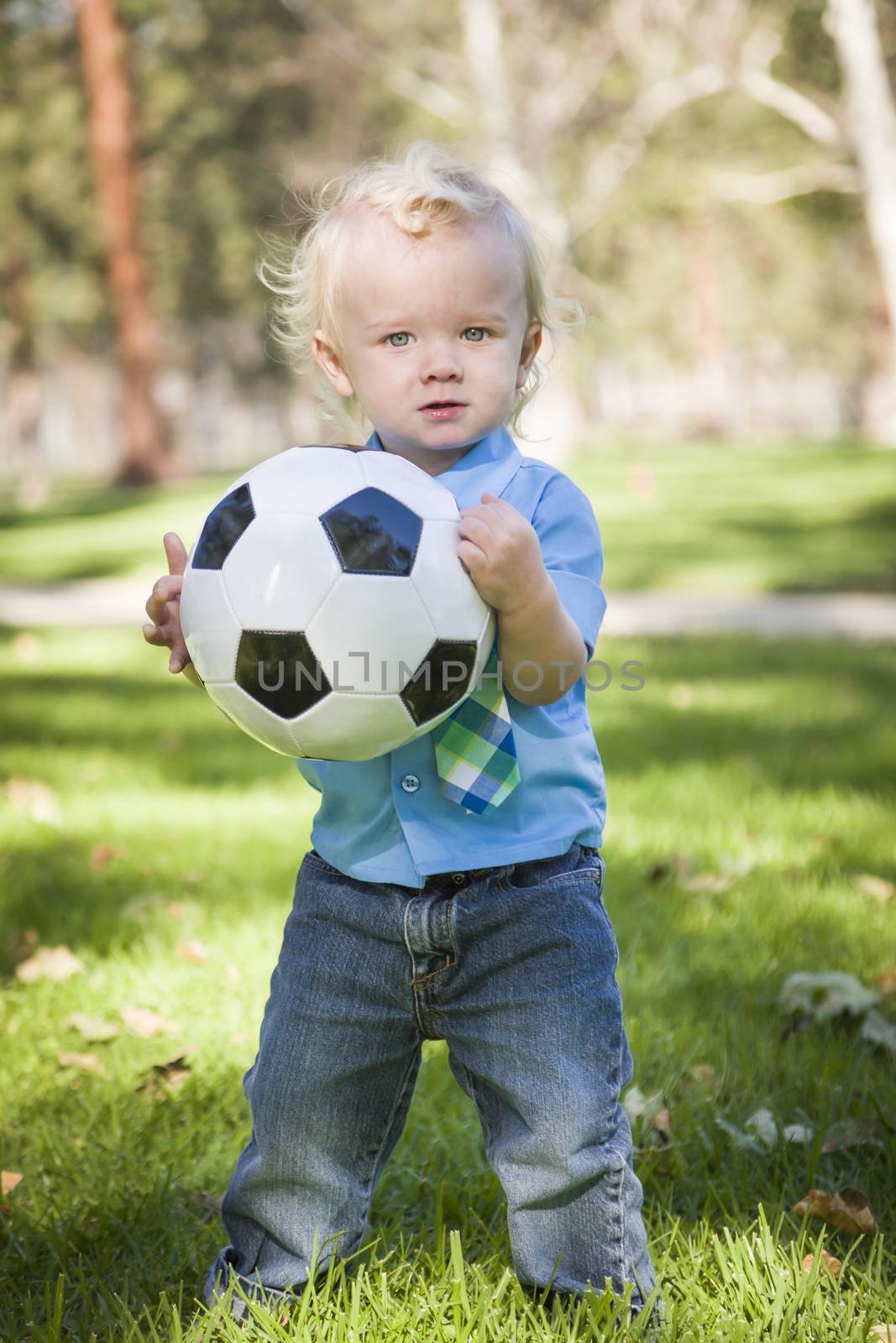 Young Cute Boy Playing with Soccer Ball in the Park.