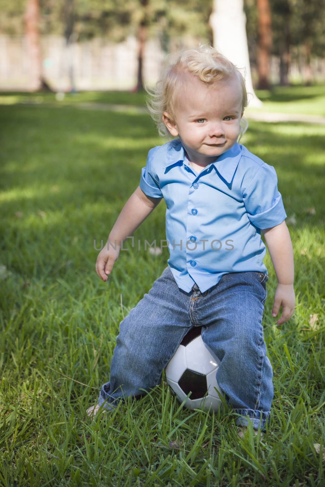 Young Cute Boy Playing with Soccer Ball in the Park.