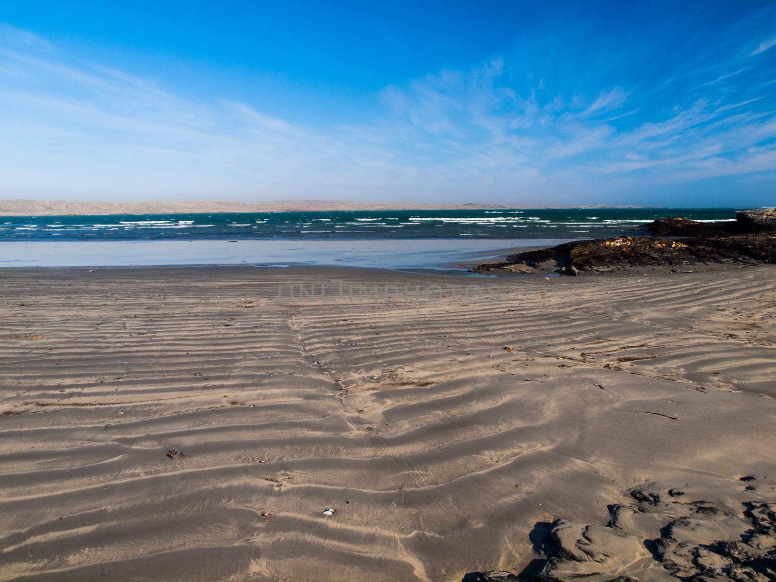 Dark sand beach, blue sky and wild Atlantic Ocean Dark sand beach and blue sky