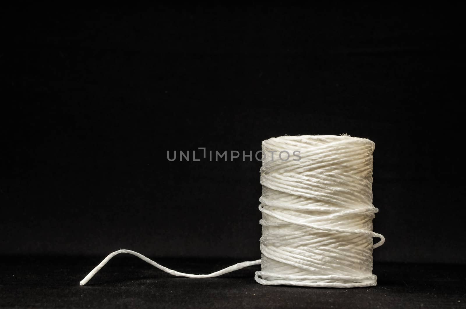 Roll of White Twine on a Black Background