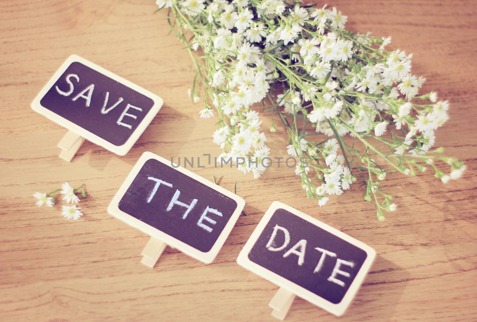 Save the date written on blackboard with flower, retro filter effect