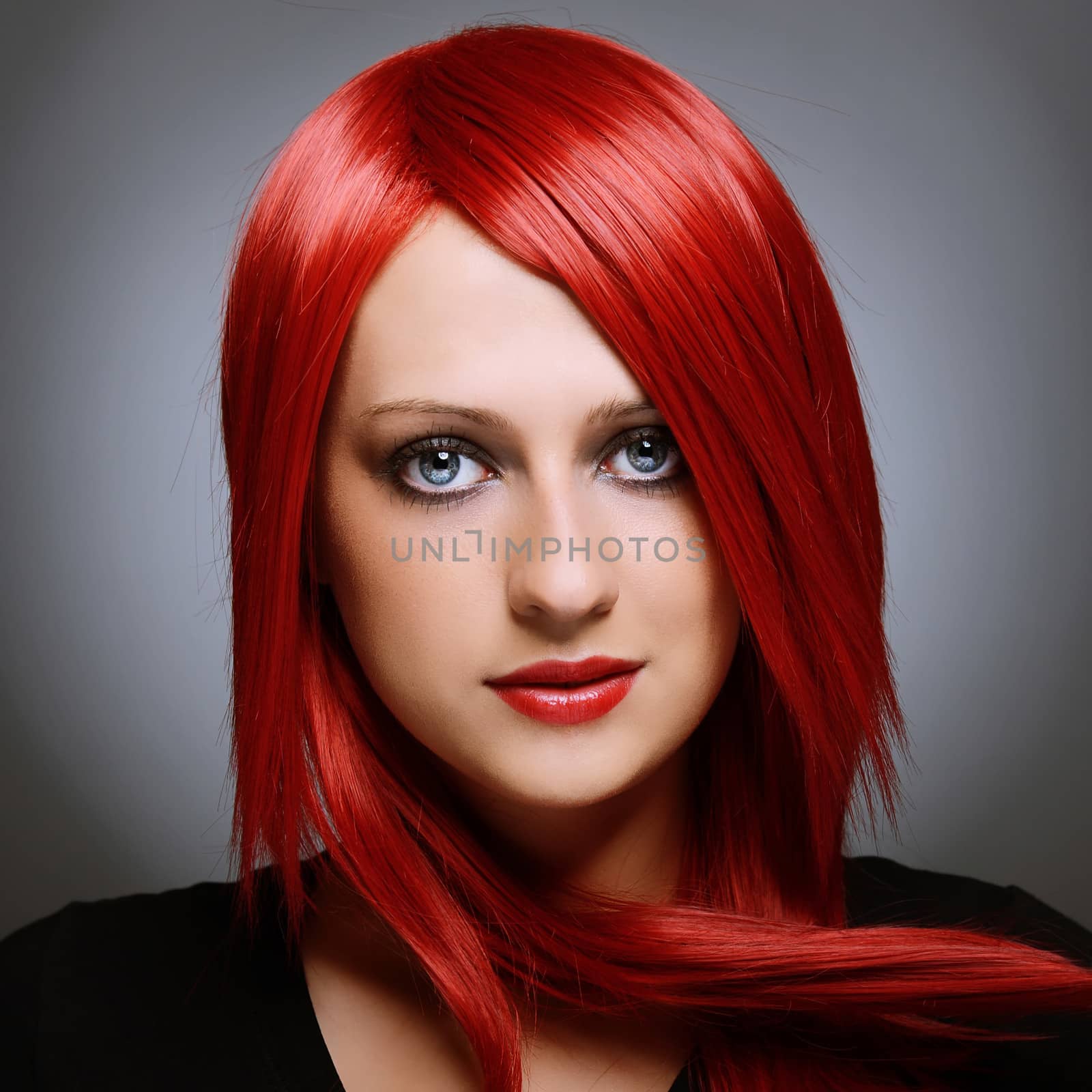 Beautiful red haired woman over gray background