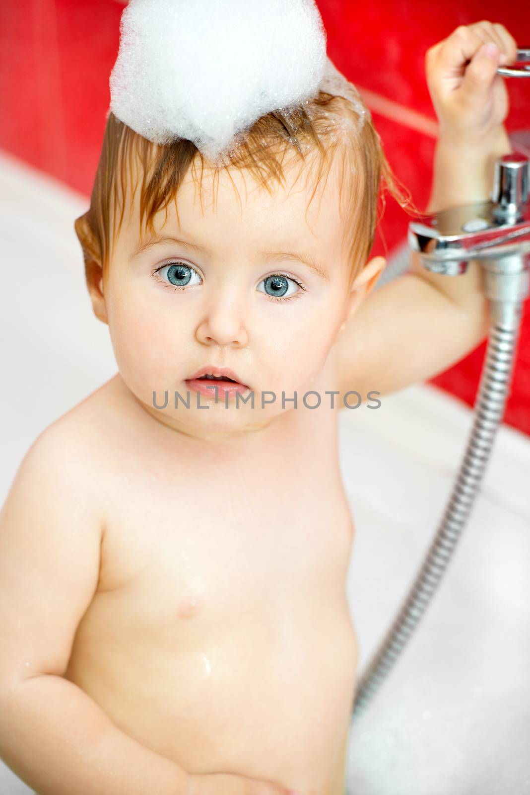 little baby in a bubble bath on head