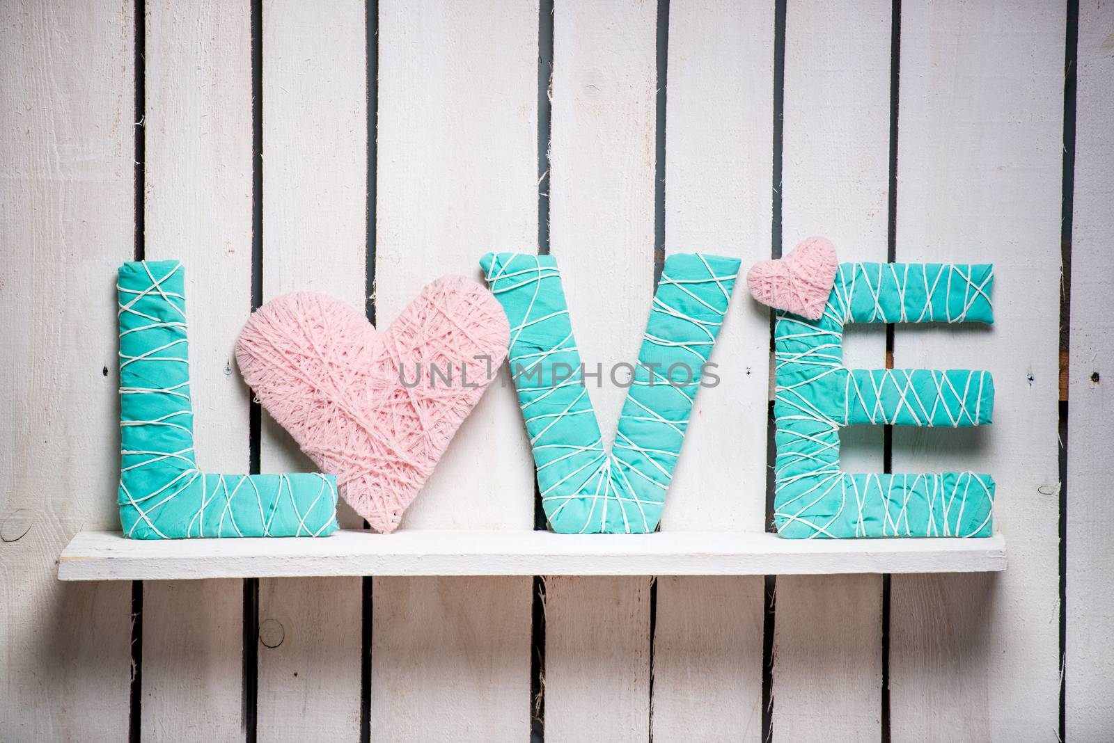 word love in delicate pink and green colors on shelf