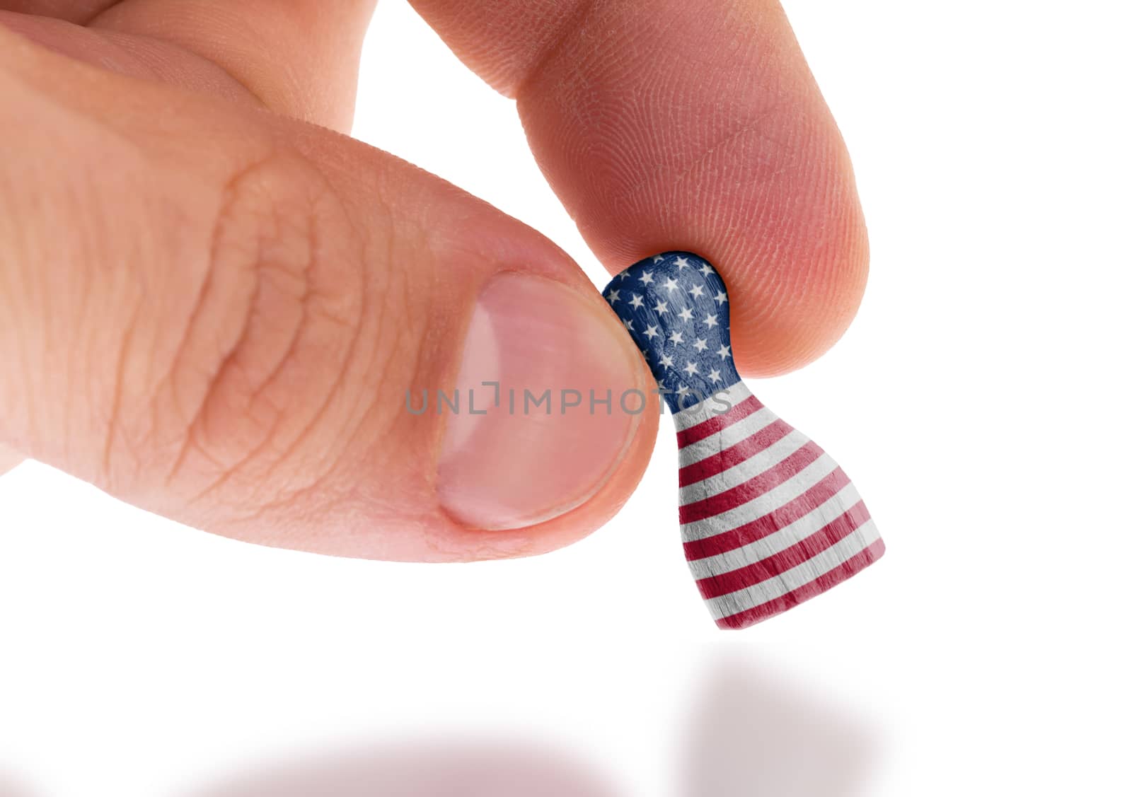 Hand holding wooden pawn, flag painting, selective focus by michaklootwijk