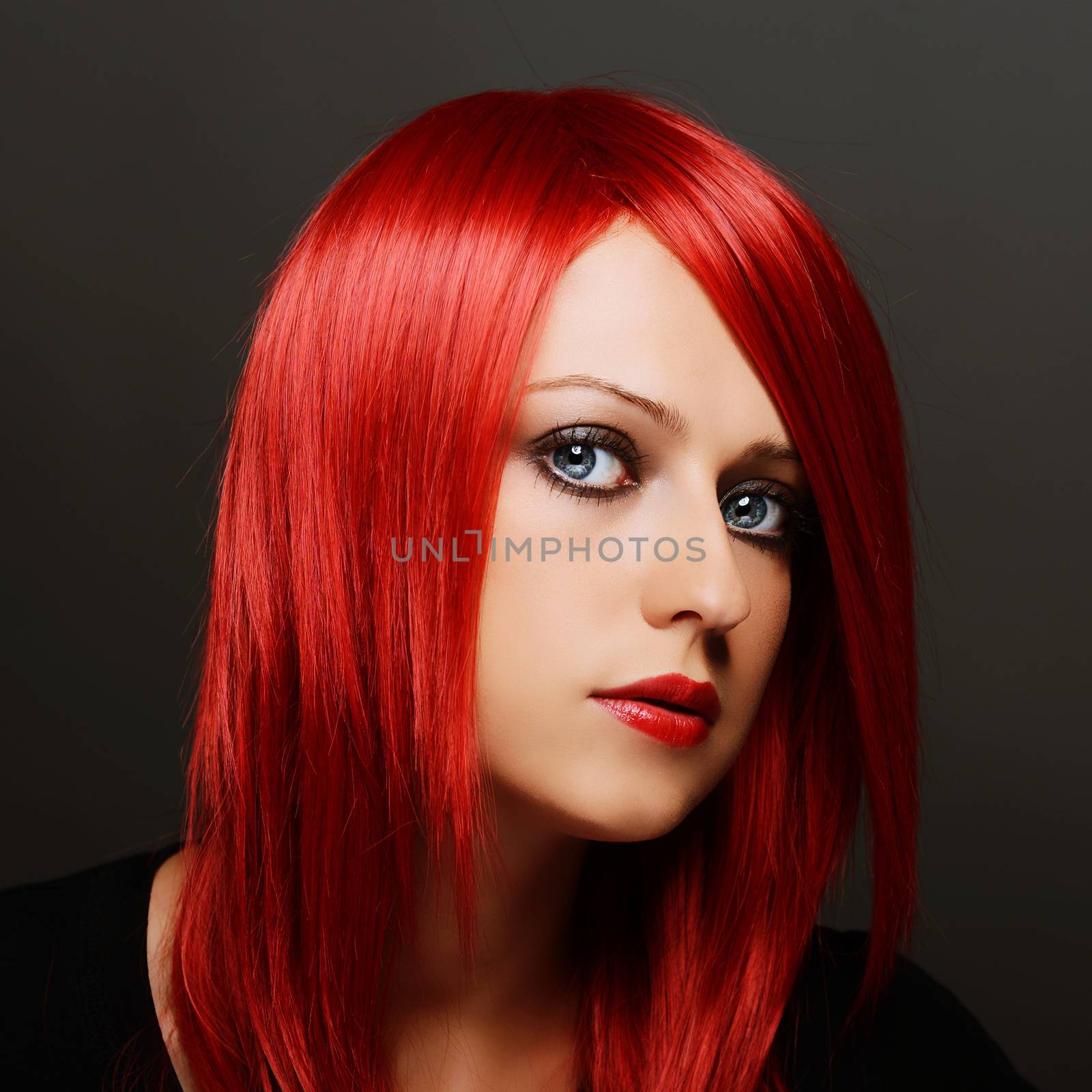 Beautiful red haired woman over dark gray background