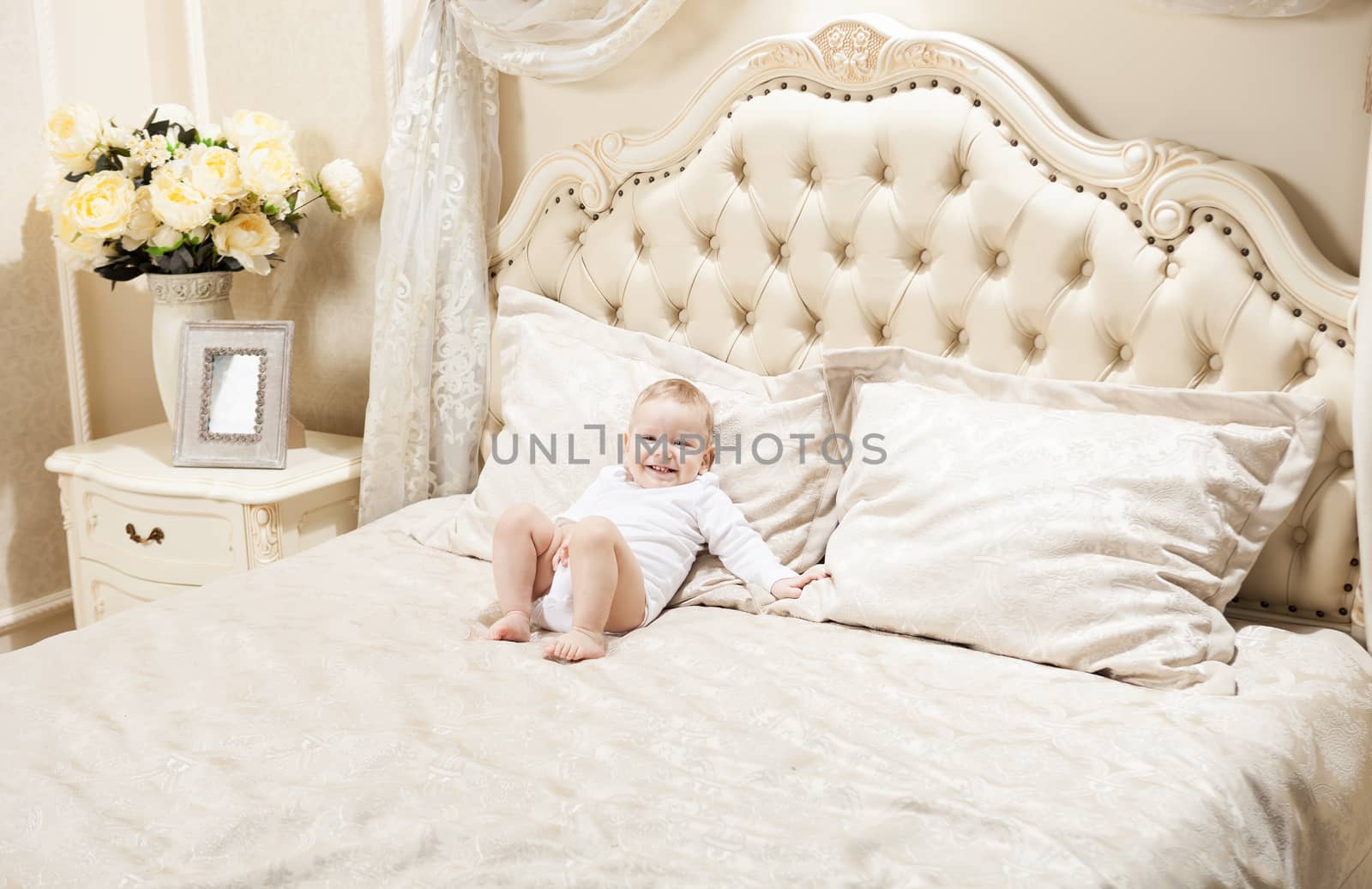 Little boy lying on bed by photobac
