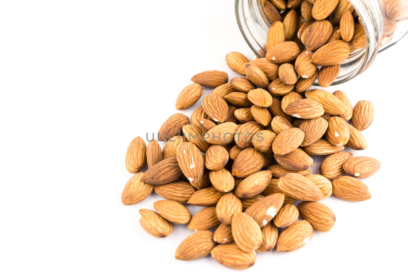 almonds nuts in glass bottle isolated on white background 