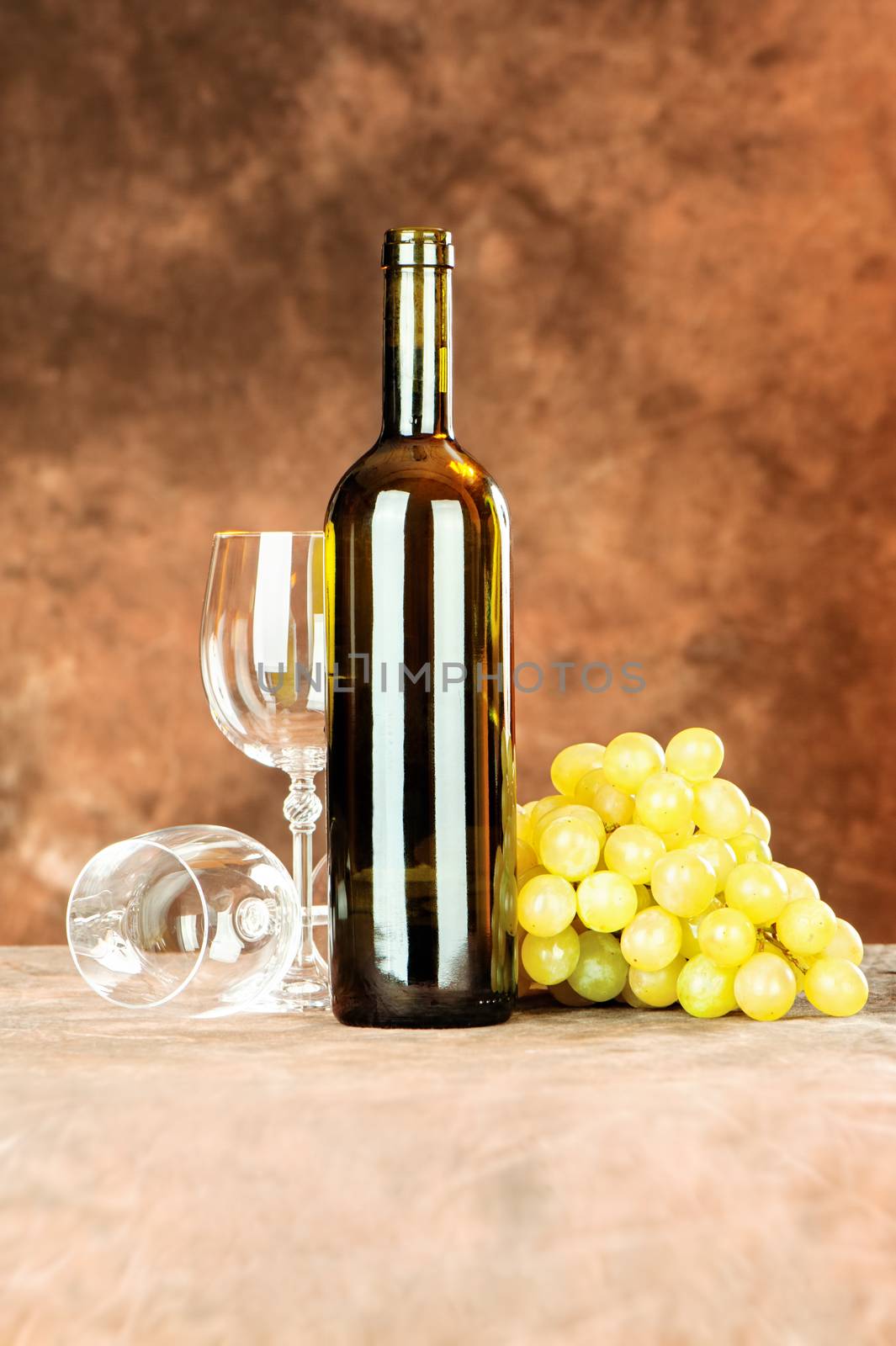 Wine bottle and shiny wine cup near grape