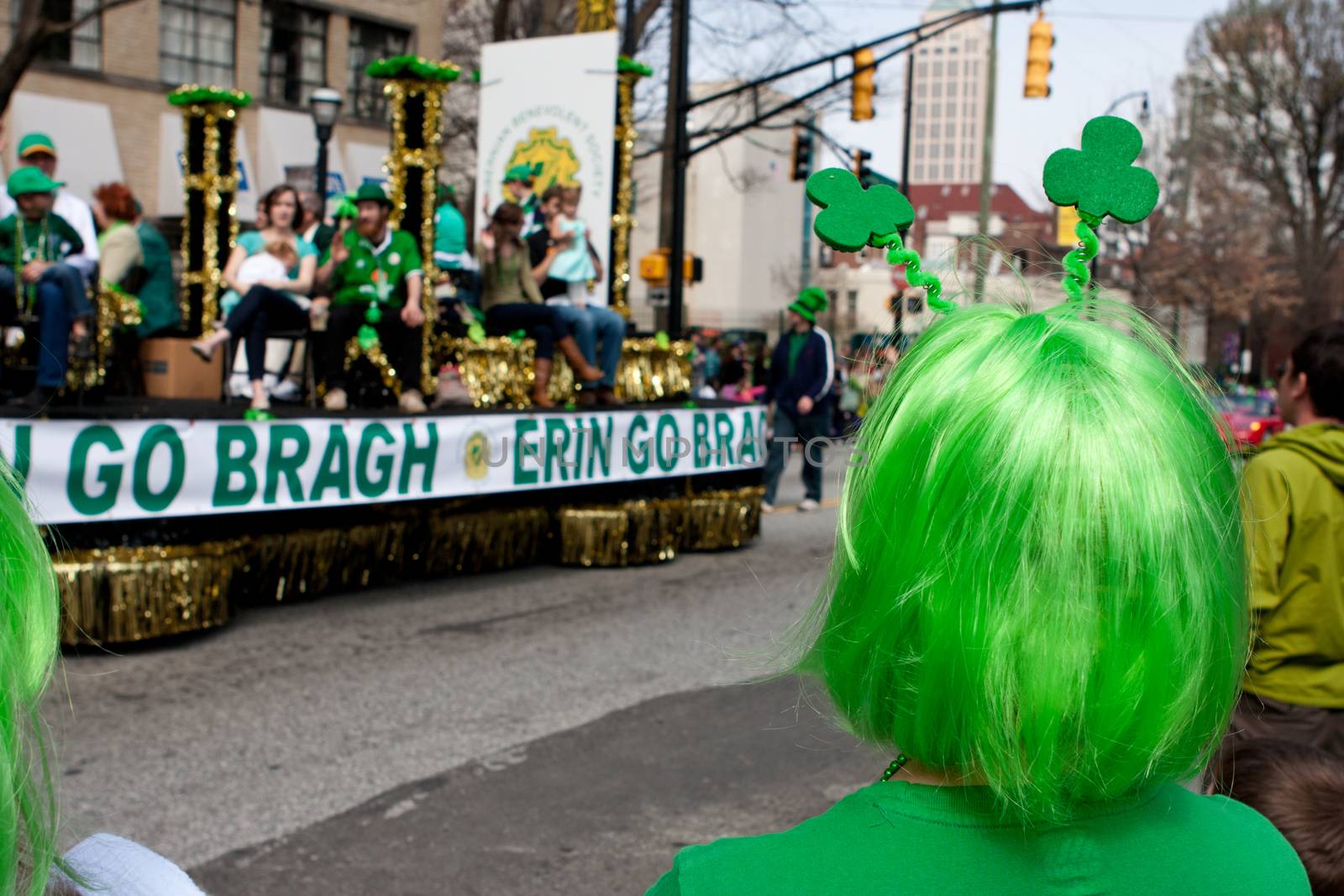 Atlanta, GA - March 15, 2014:  A woman wearing a green wig watches a parade float go by at the annual St. Patrick's parade.