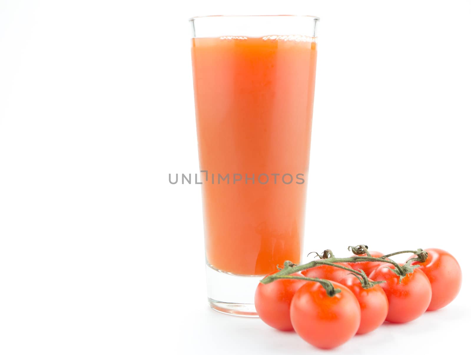 Drinking glass with tomato juice and ripe fresh tomato on the white background 