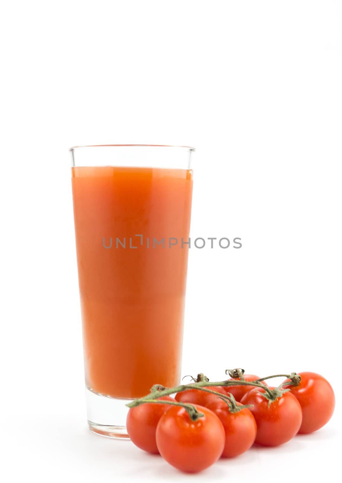 Drinking glass with tomato juice and ripe fresh tomato on white background