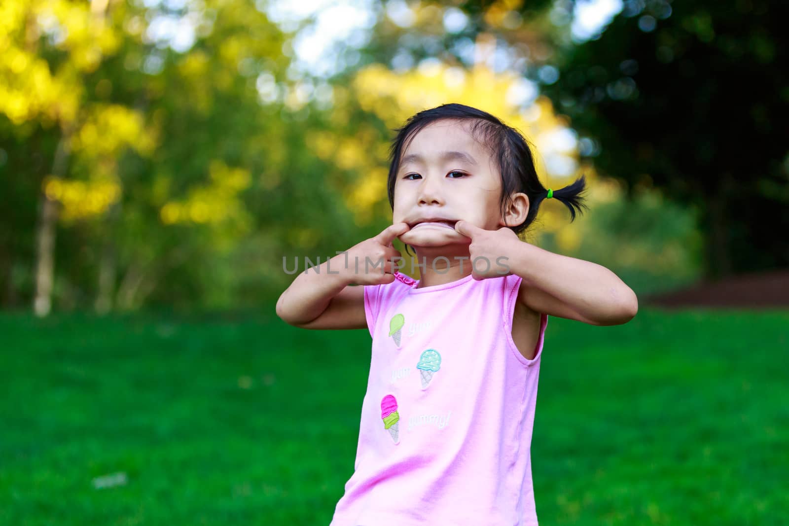 Adorable girl making faces in the park