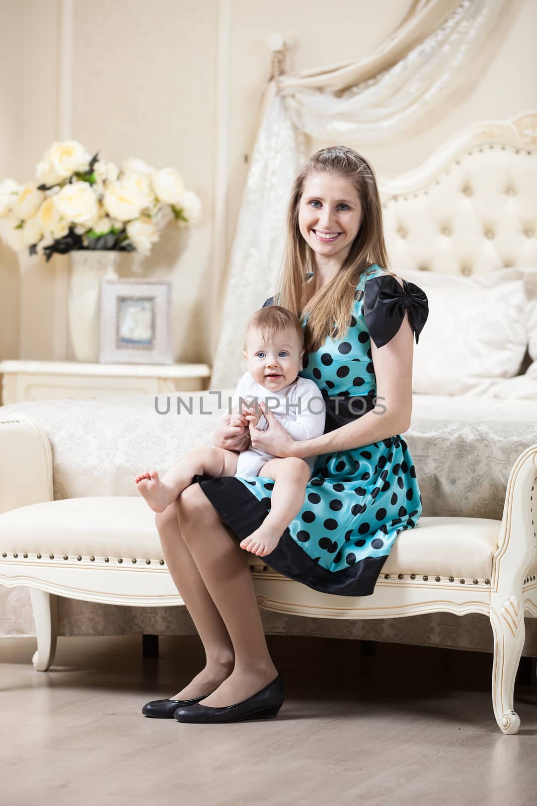 Woman with little son sitting on couch in bedroom by photobac