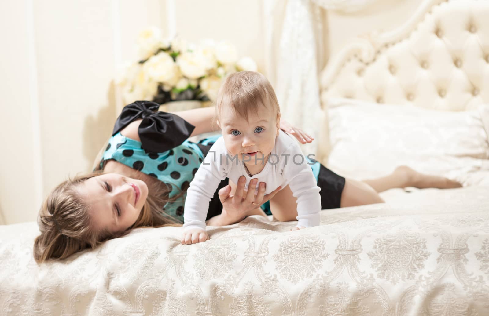 Caucasian mother and baby son on bed by photobac