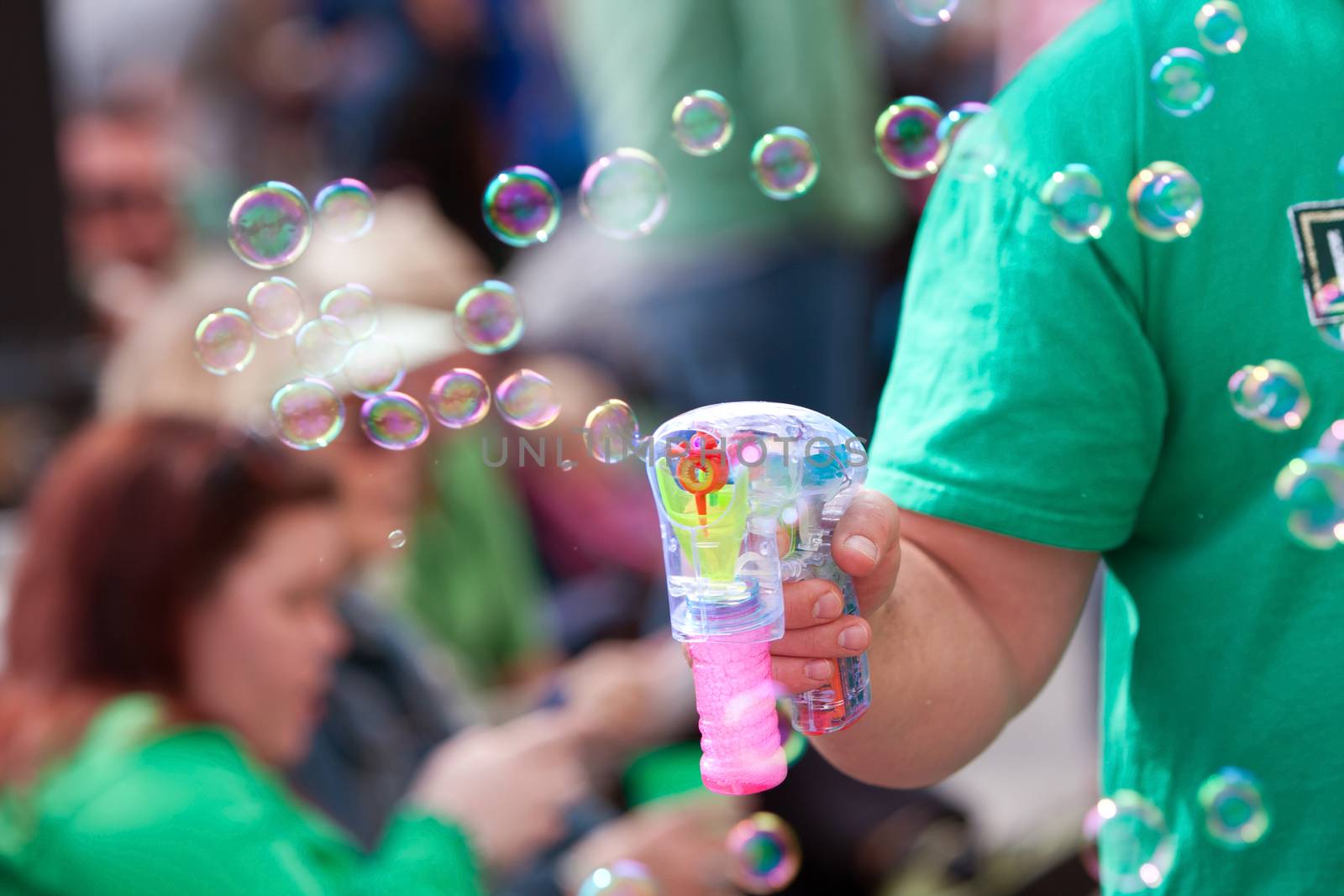 Atlanta, GA, USA - March 15, 2014:  A man uses a bubble gun to blow bubbles at the St. Patrick's Day parade on Peachtree Street.