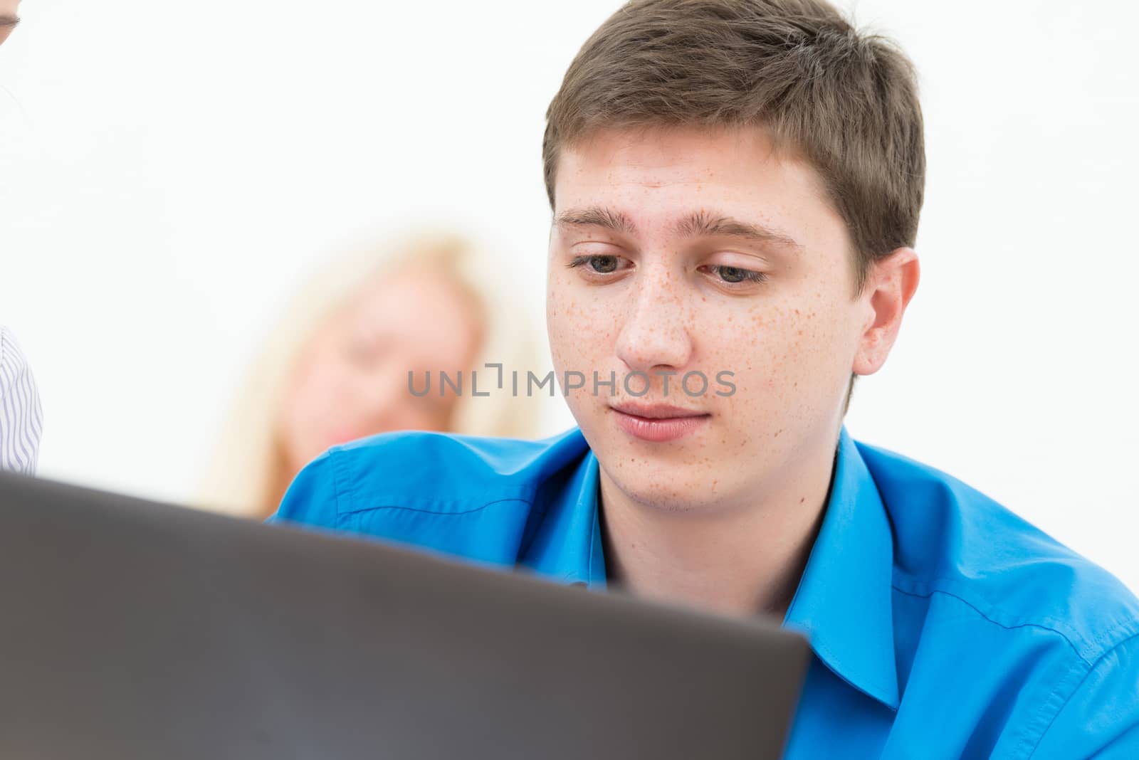 Portrait of a young student in the classroom, working with a laptop