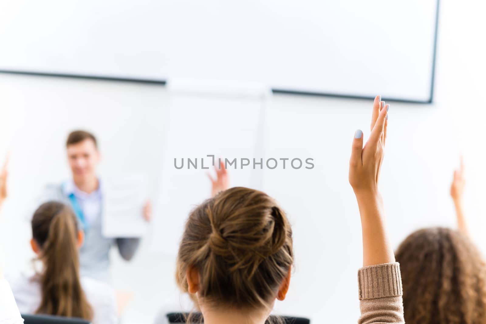 image of a female hand raised in university classroom