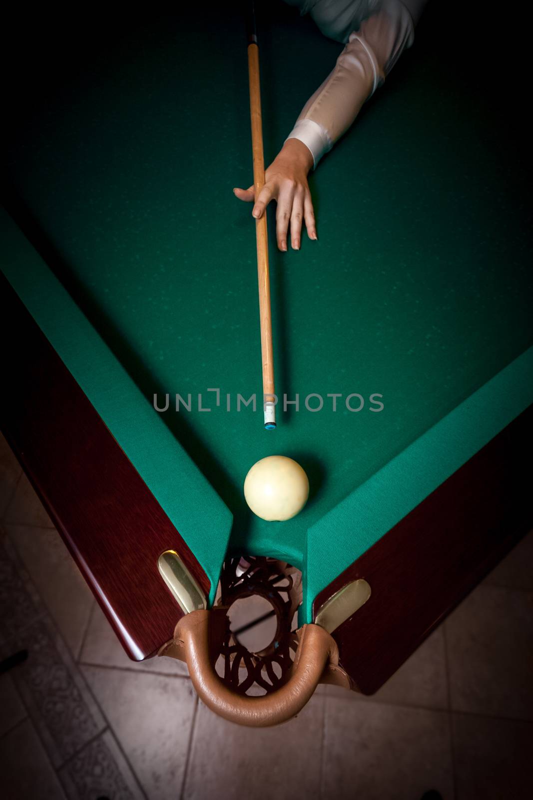 Woman aiming at billiard pocket with white ball