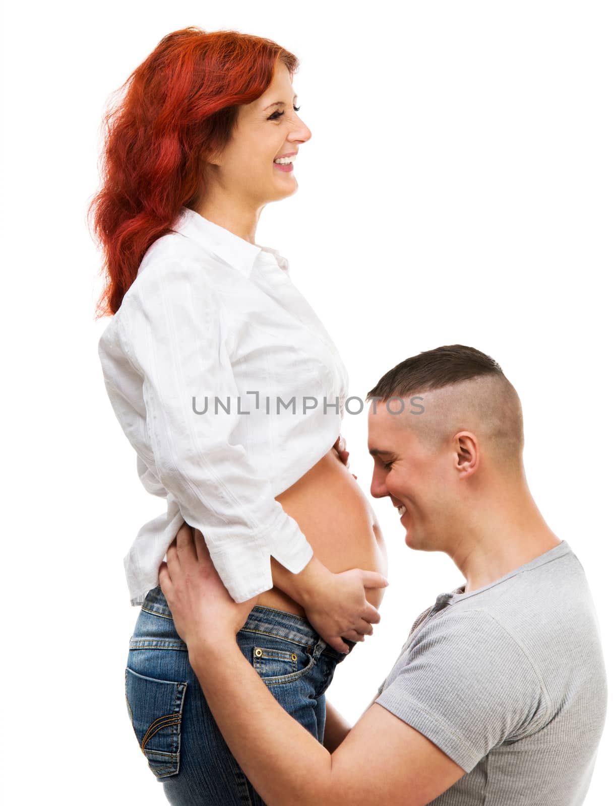 Husband hugs his pregnant wife isolated on white