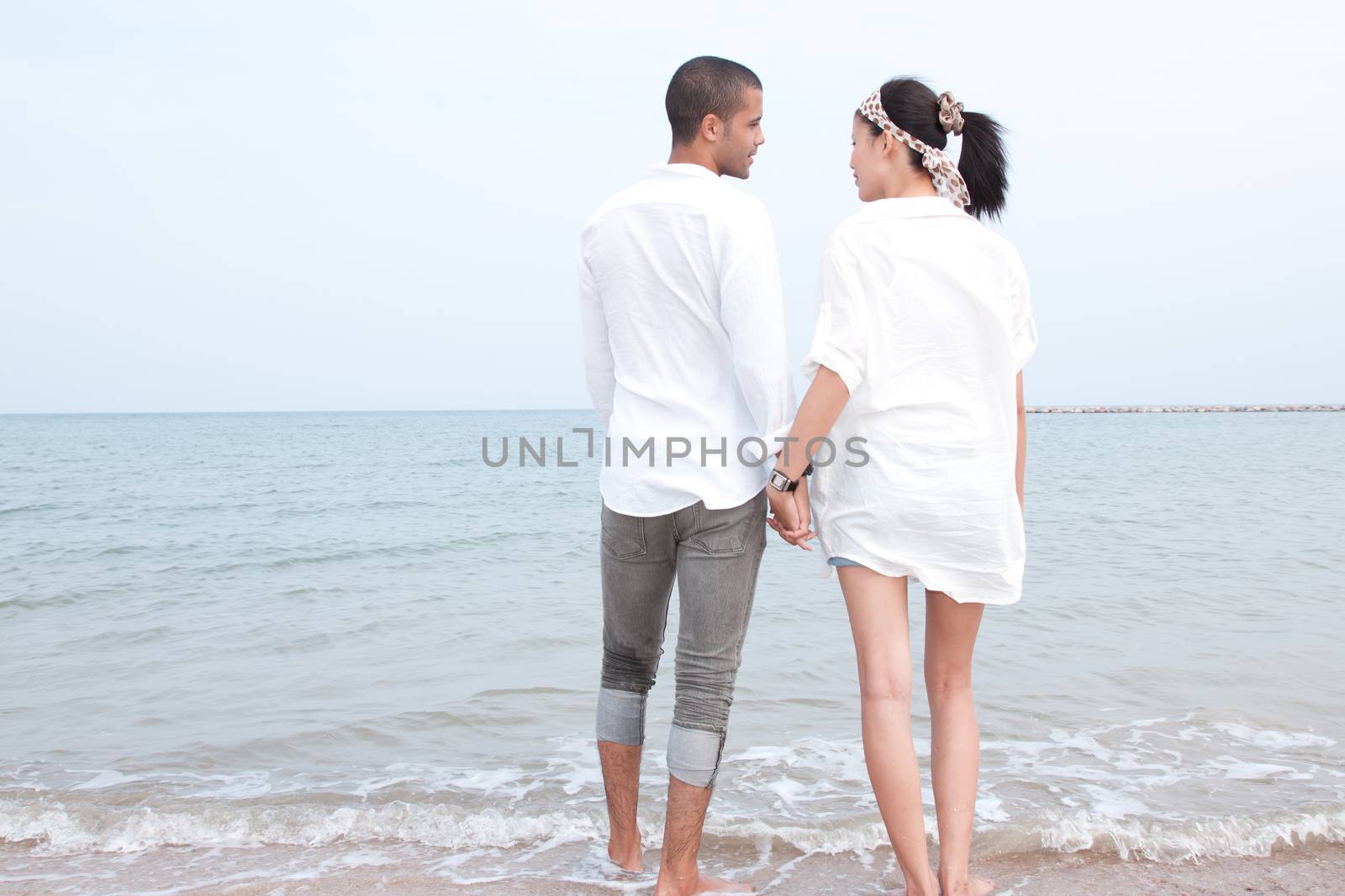 african man and asian woman lover on the beach