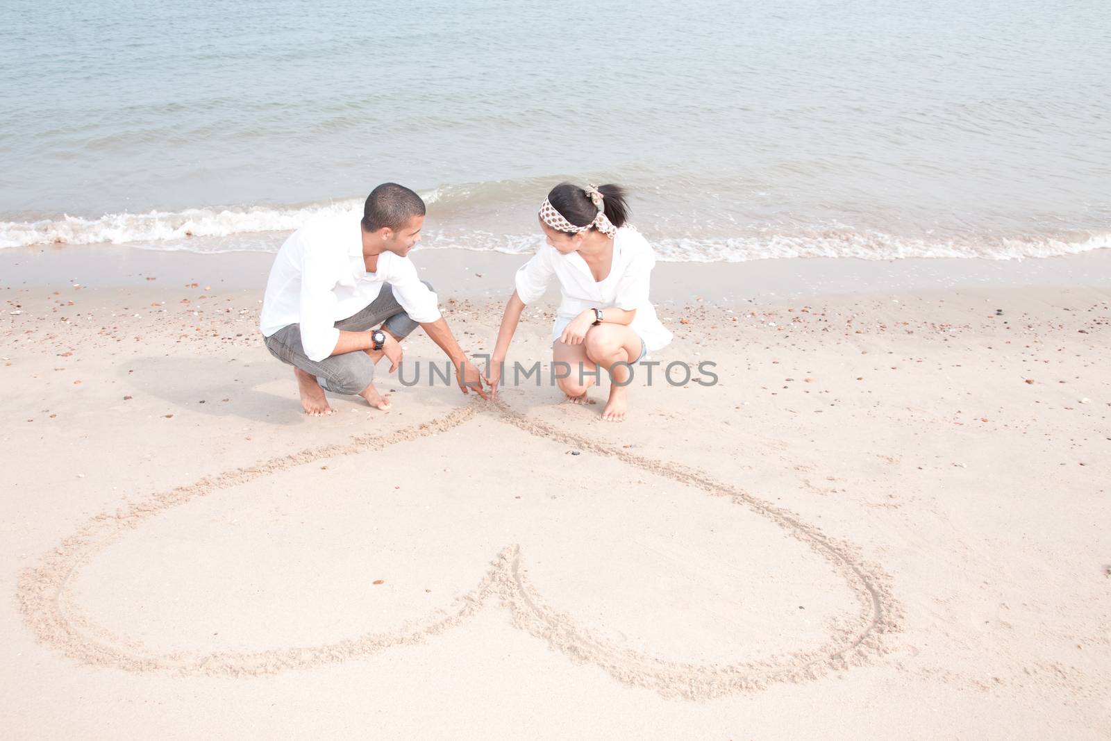 african man and asian woman lover on the beach