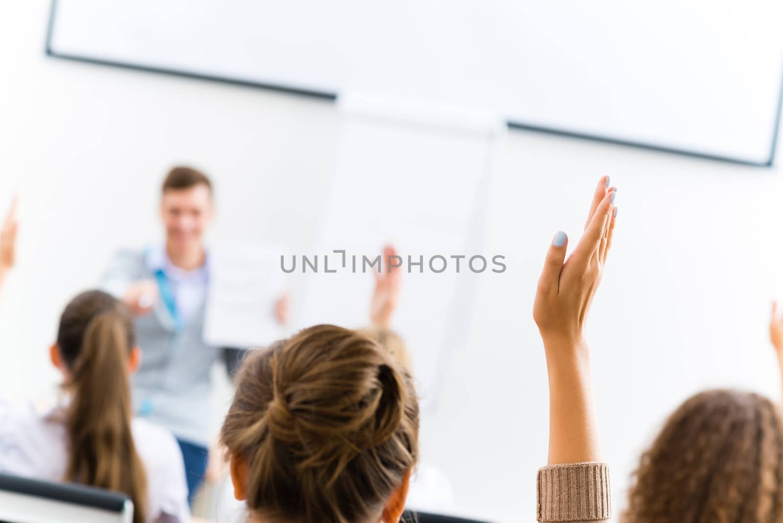 image of a female hand raised in university classroom