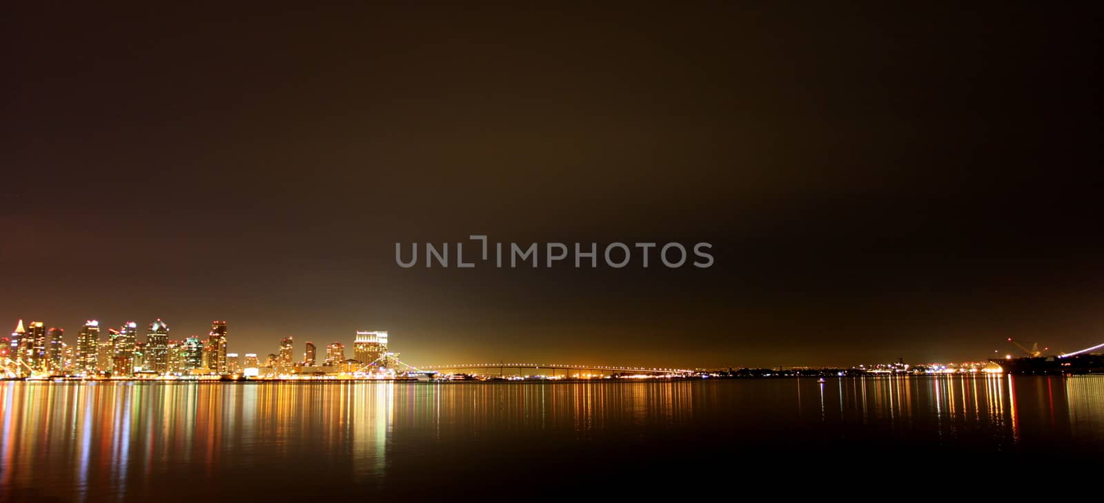 The skyline of San Diego at night with reflection in the water.