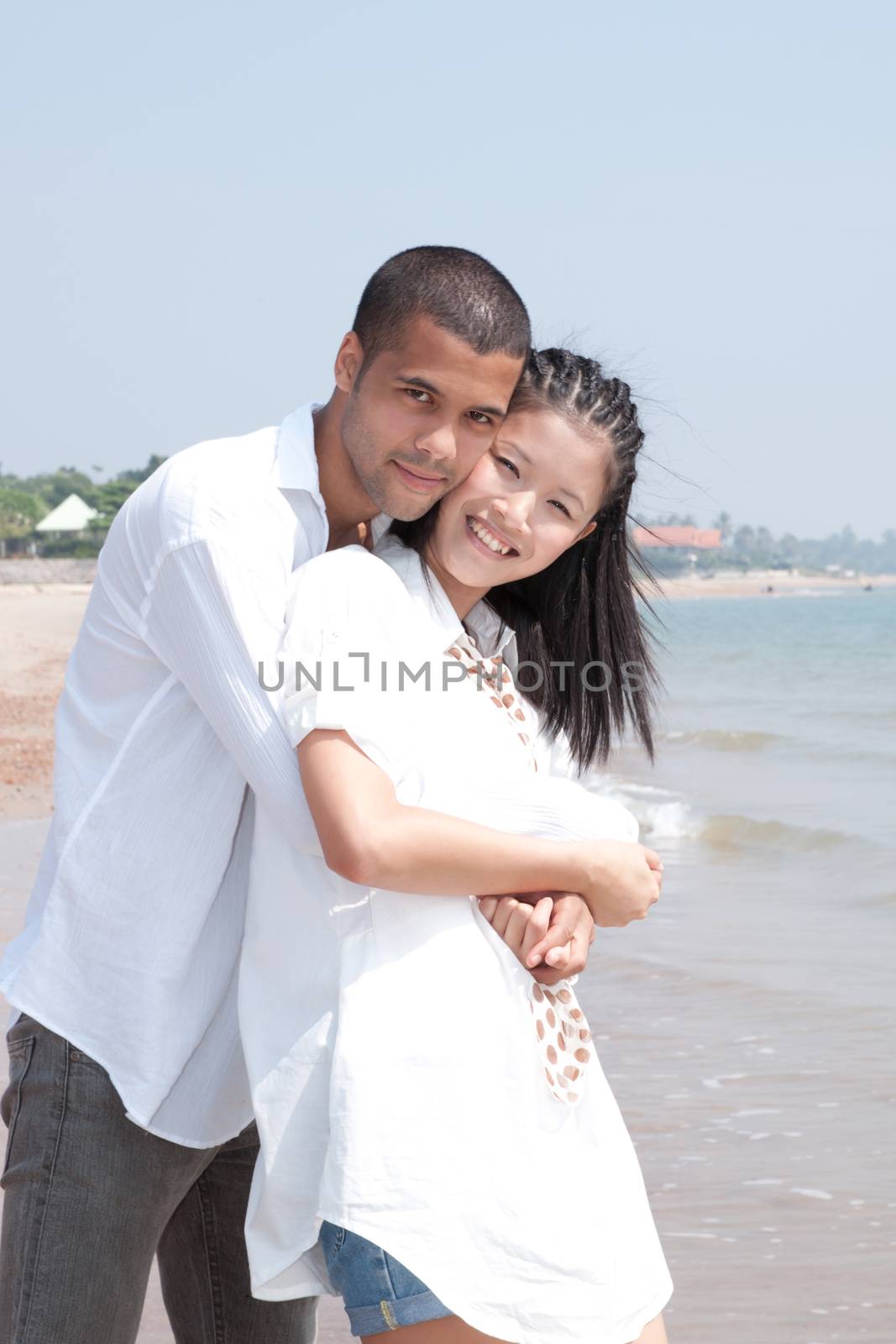 african man and asian woman lover on the beach