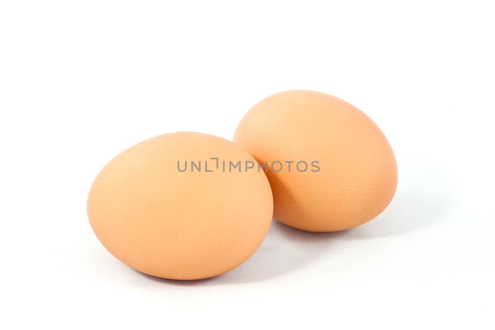 Two brown eggs isolated on white background