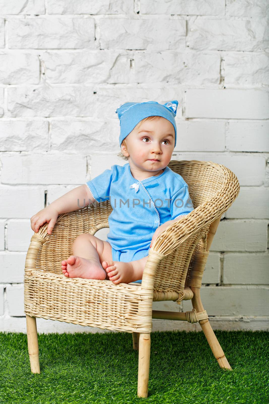 Little boy sitting in wicker chair by Vagengeym