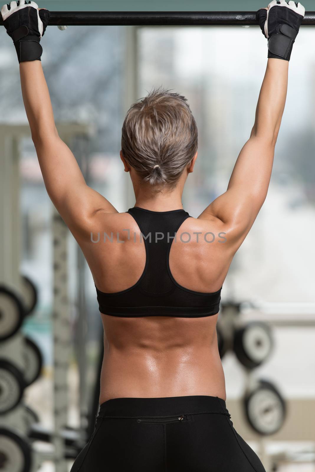 Female Athlete Doing Pull Ups - Chin-Ups In The Gym