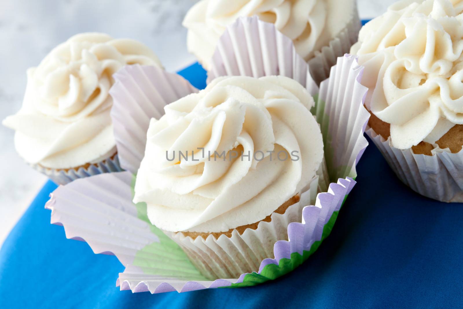 Close up of decadent gourmet cupcakes with vanilla frosting. 